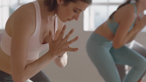 Schöne-Yoga-Frau-übt-Krieger-Pose-Im-Fitnessstudio-Bei-Sonnenaufgang.-Kaukasische-Frau-Trainiert-Mit-Einer-Gruppe-Multiethnischer-Frauen,-Die-Einen-Gesunden,-Ausgewogenen-Lebensstil-Genießen