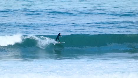 Panning-clip-of-surfer-riding-a-waves-blue-ocean-in-europe-beach