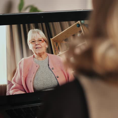 woman communicates with elderly lady via video call