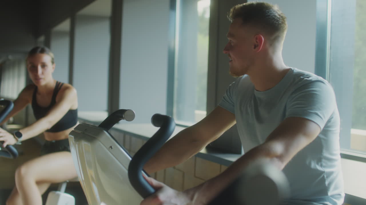 Couple Cycling on Gym Bikes and Talking