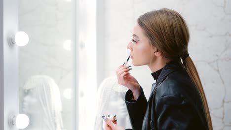young woman applying makeup in a beauty studio