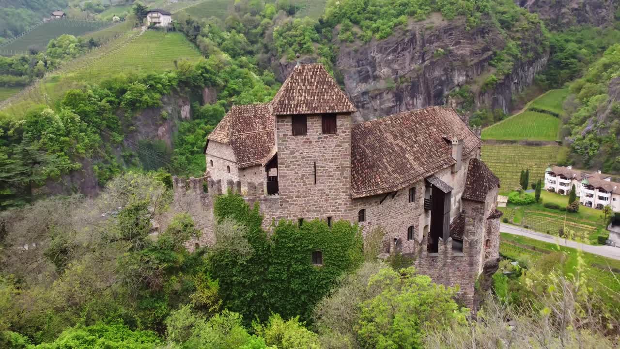 Ancient Roncolo Castle perched amidst green hills in South Tyrol, Italy