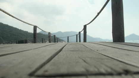 close up of a wooden walkway on an island in thailand, pulling focus from foreground to background