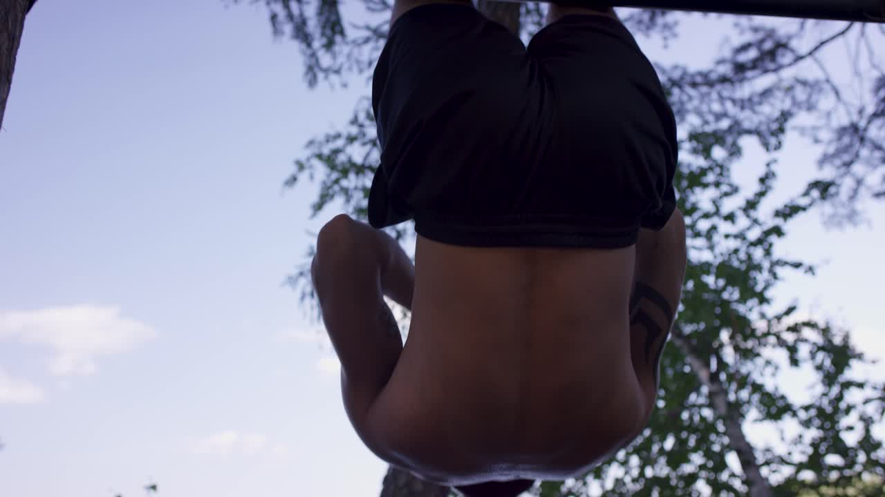 hombre realizando pull-ups al aire libre