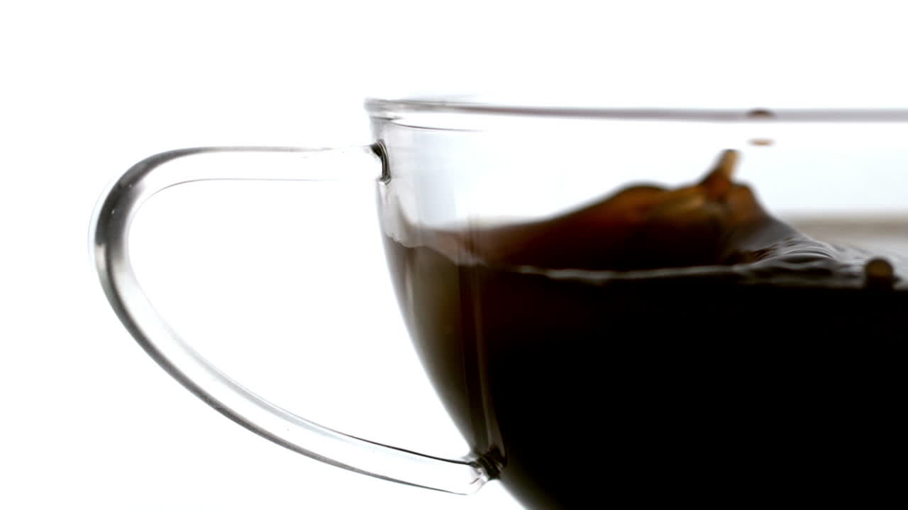 설탕 큐브가 커피 컵에 떨어지는 것