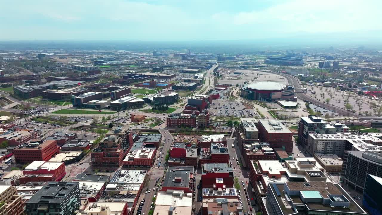 Downtown Denver spring summer after rain thunderstorm aerial drone Colorado cityscape landscape buildings Ball Arena sunny blue skies cloudy afternoon i25 cars traffic university circle left motion