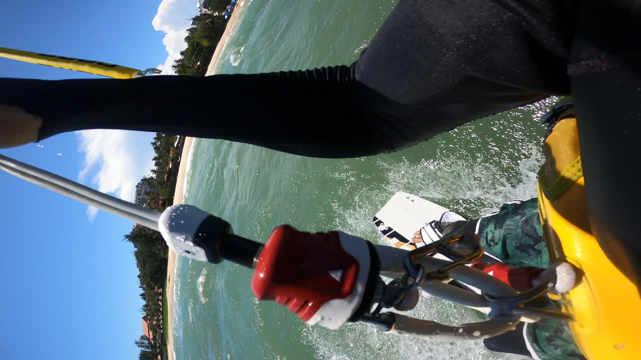 카이트보더가 파워 카이트에 의해 물을 가로질러 끌려가는 세로 샷