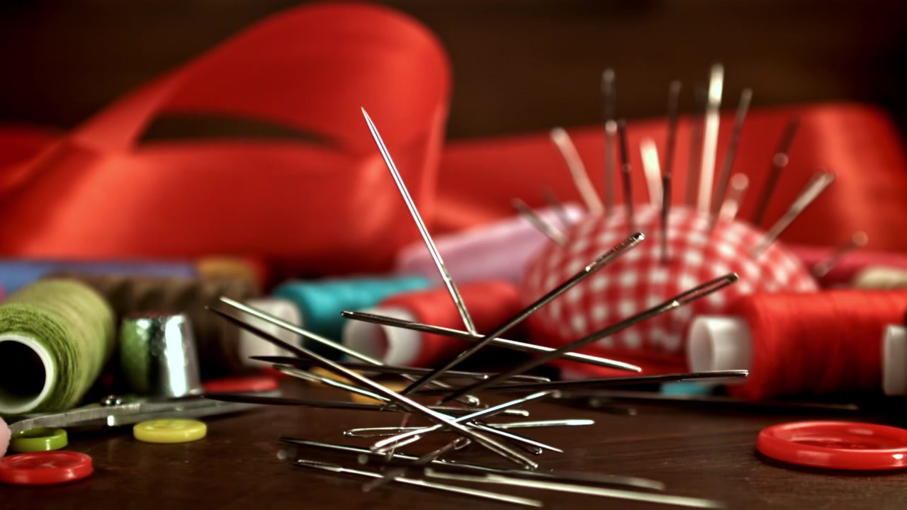 Sewing Needles Falling in Slow Motion Amidst Craft Supplies