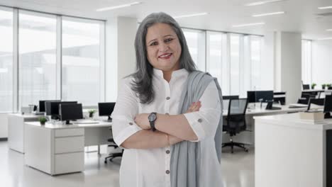 feliz mujer de negocios india de pie con las manos cruzadas