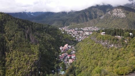 vista aérea de la rueda gigante en la cima de las montañas rodeada de bosque nube niebla valle ciudad