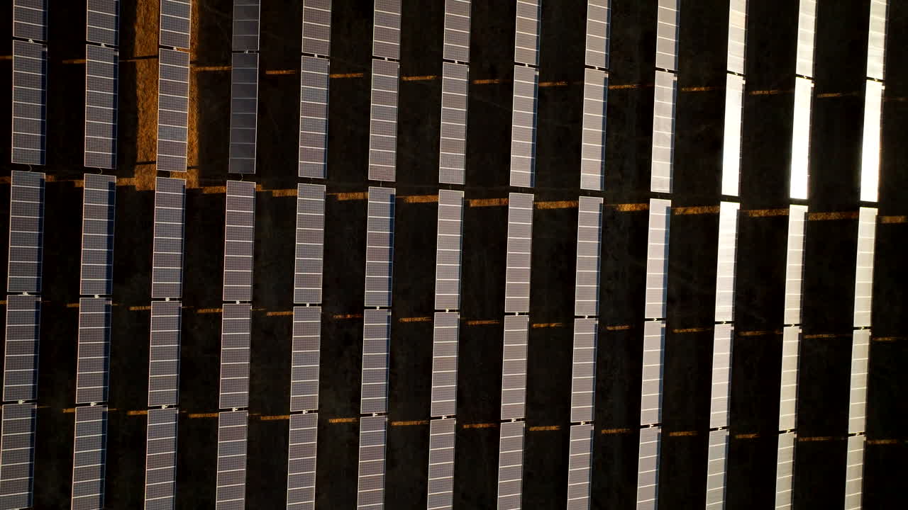 Abstract drone riser view over rows of PV solar panels, combating climate change