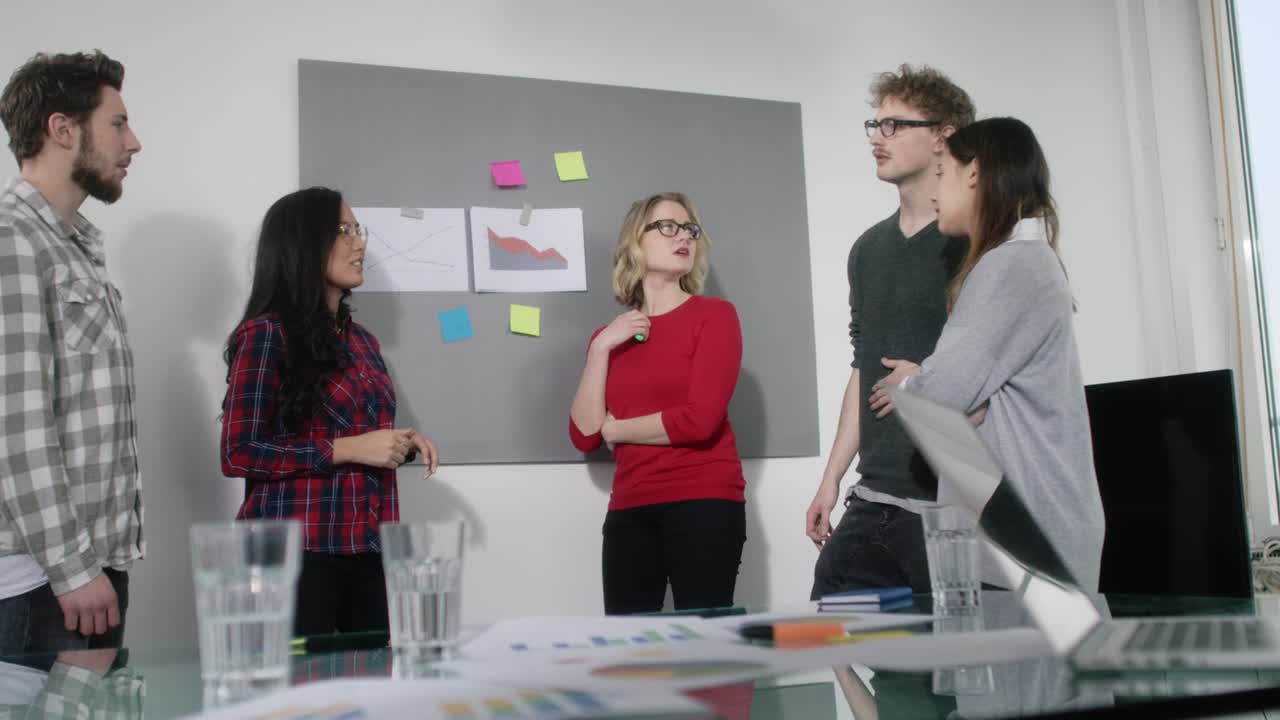 Group of young business people analysing statistics