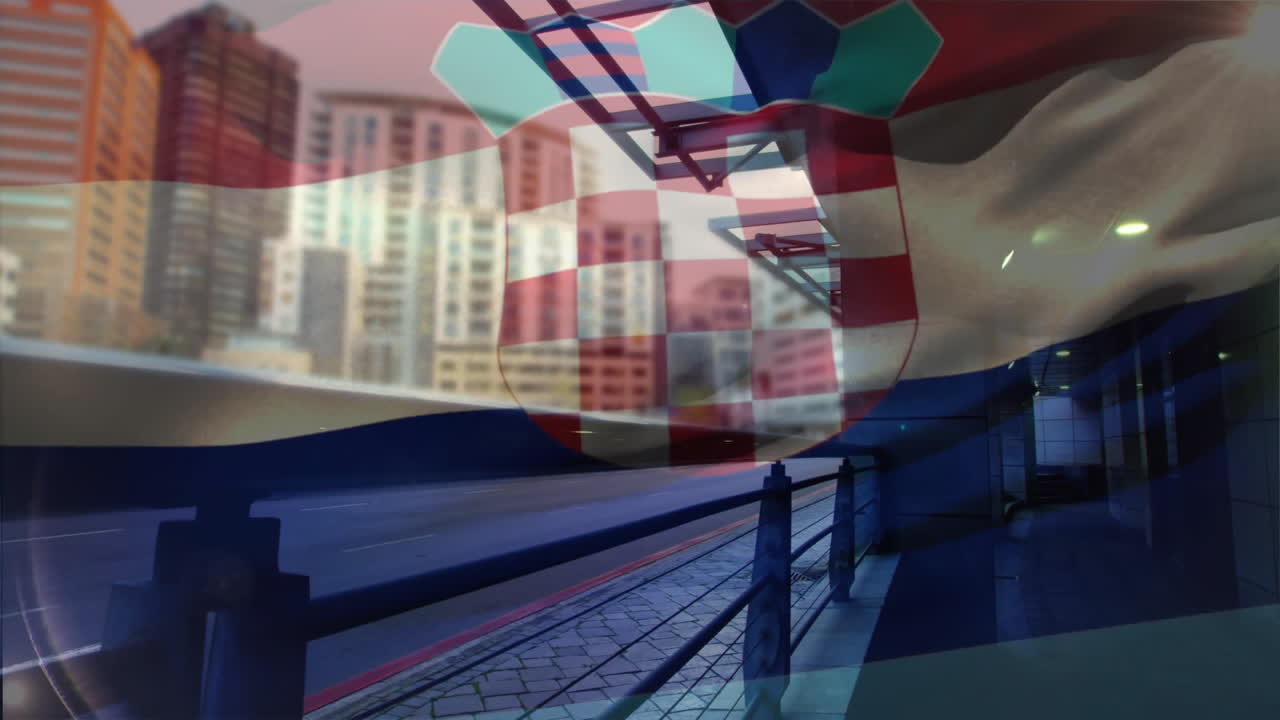 Croatian flag fluttering over urban street showing metal railing, sidewalk and high?rise towers