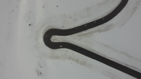 snowy white winter landscape, car drive sharp road turn, top down aerial view