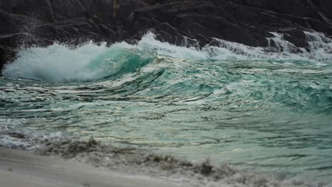 powerful waves are crashing on the rocks and spilling on the sandy beach-1