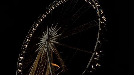 the budapest eye - large illuminated ferris wheel with light during nighttime - tilt down shot