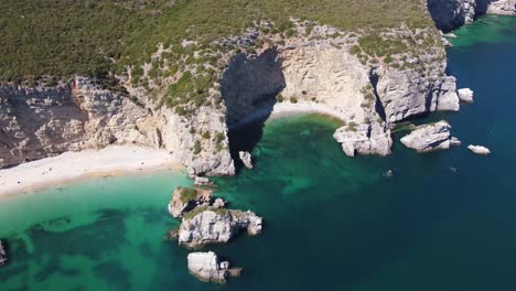 Una-Toma-Aérea-En-órbita-De-Una-Playa-En-Forma-De-Media-Luna-En-Portugal