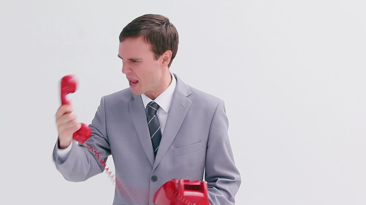 화가 난 사업가 가 전화 를 하고 있다