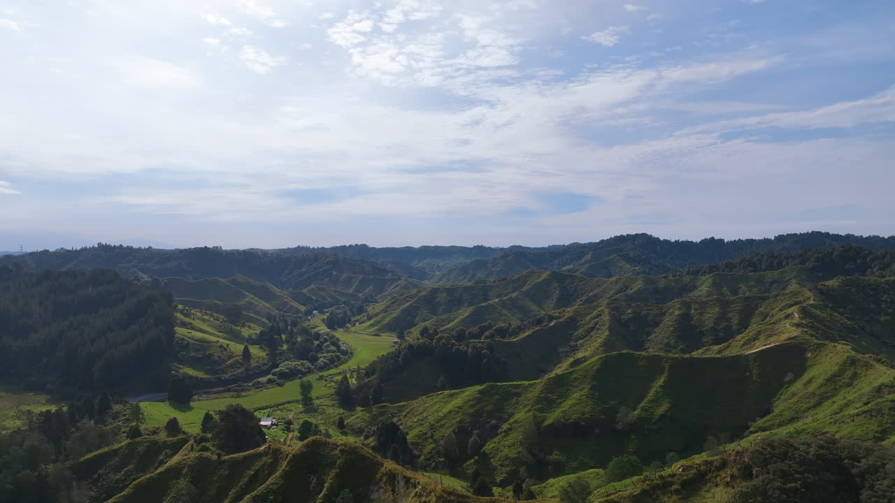 vuelo a través de escarpadas colinas verdes para revelar fértiles prados exuberantes ocultos en lo profundo del paisaje olvidado de la autopista mundial de nueva zelanda, el este de taranaki aotearoa