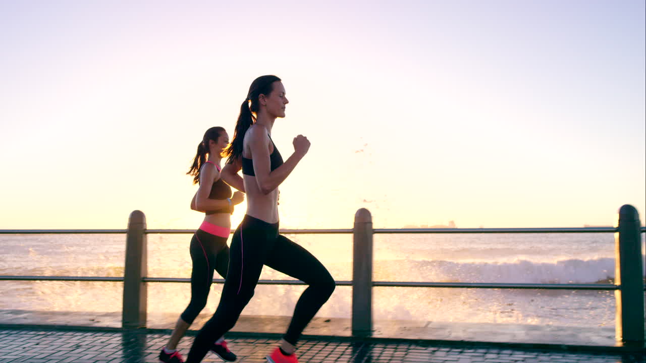 due amici che fanno jogging sul lungomare al tramonto