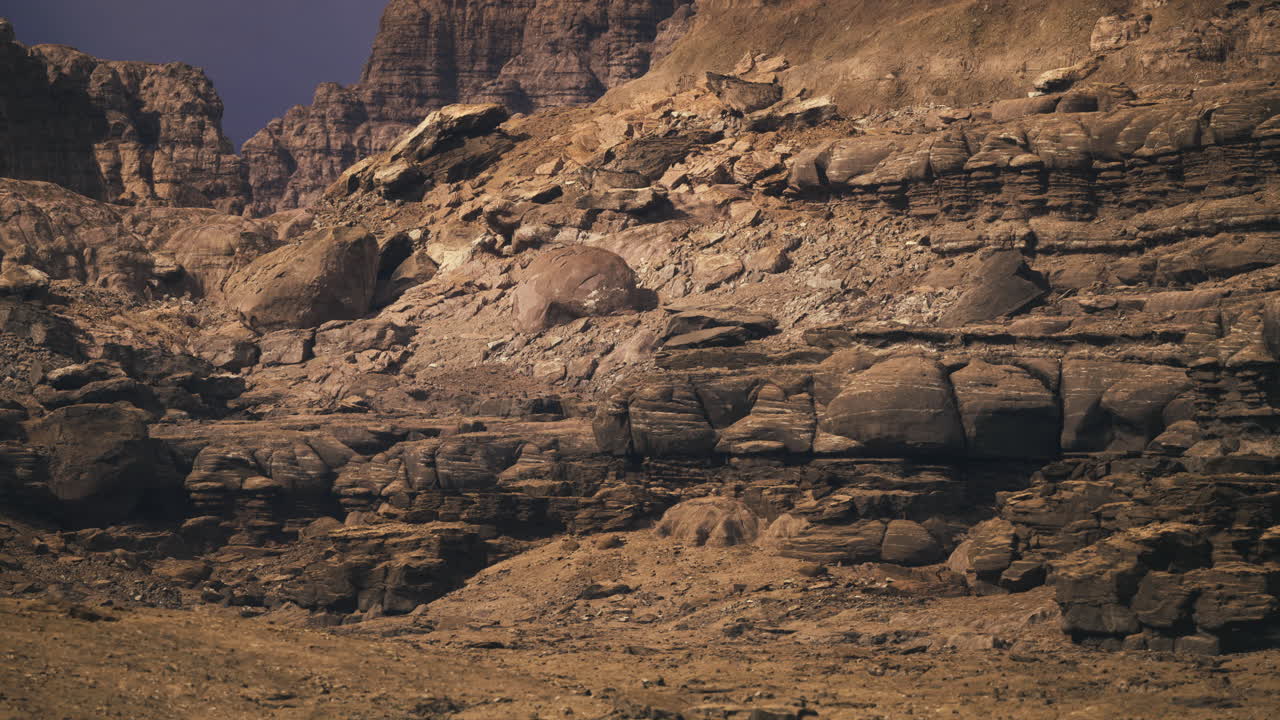 Barren rocky landscape with layered formations in a desert setting