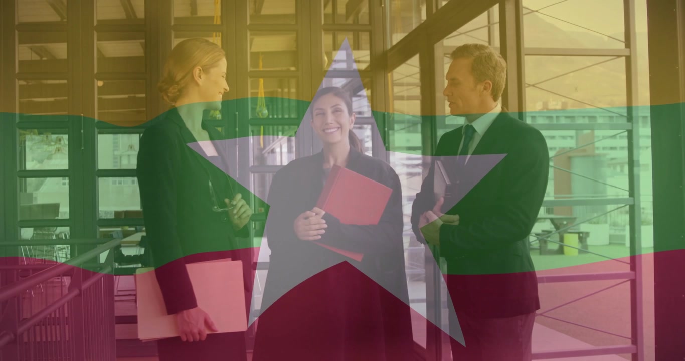 Kvinde i centrum flytter rødt ringbind og møder teamet, indleder kontorsnak mens et flag-overlay toner ud