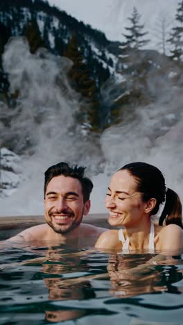 pareja relajándose en una bañera de agua caliente en las montañas de invierno