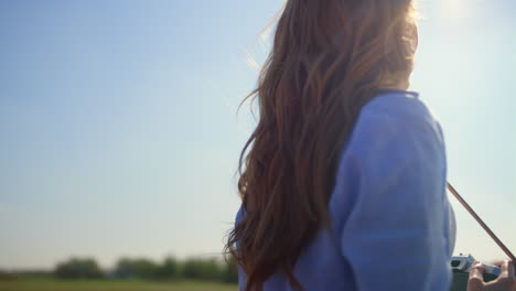 Vista-Posterior-De-Una-Mujer-Desconocida-Con-Cámara-Fotográfica-Disfrutando-De-La-Luz-Del-Sol-En-El-Jardín-De-Primavera.