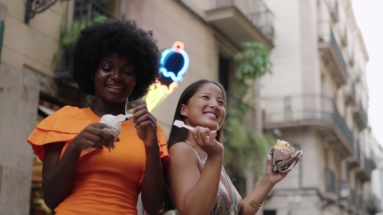 Two friends enjoying ice cream on a city street