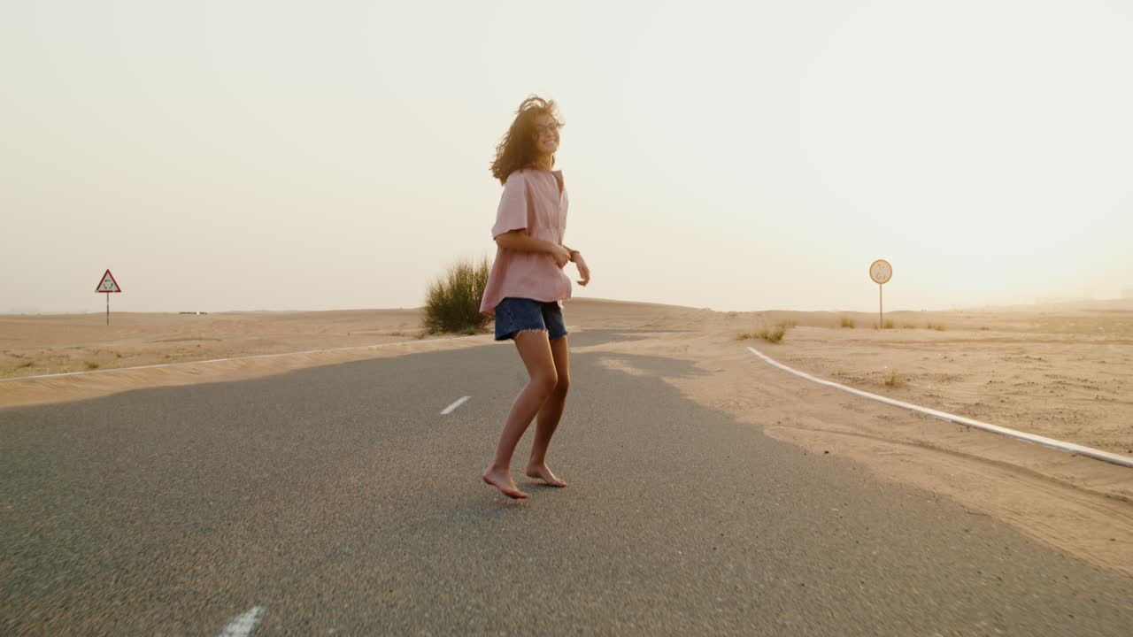 Donna che corre su una strada nel deserto all'alba/al tramonto