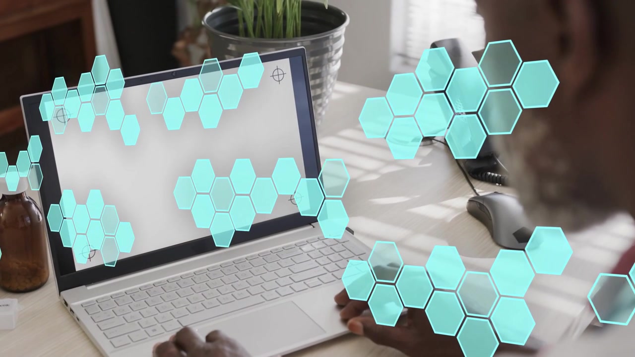 Man at desk working on laptop, tapping and swiping, animating cyan hex overlay for tech