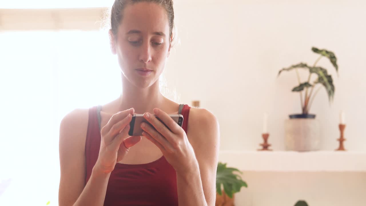 mujer caucásica usando su teléfono en casa