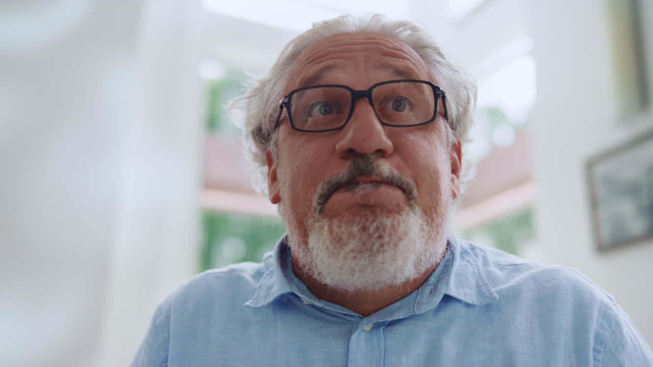 hombre maduro posando ante la cámara en casa. hombre mayor haciendo emoción sorprendida