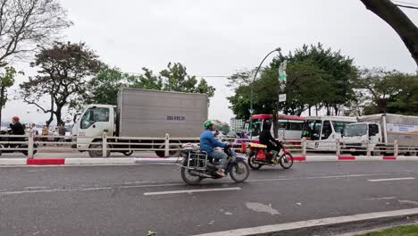 motorbikes and trucks on a bustling street