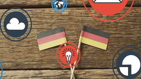 animation of digital media icons over german flags on wooden background