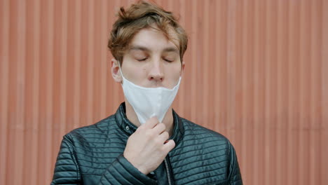 man adjusting face mask outdoors
