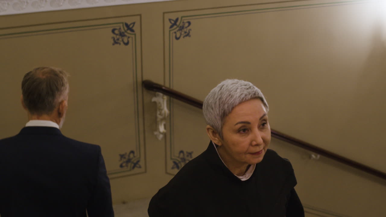 People Walking Upstairs in a Grand Hallway