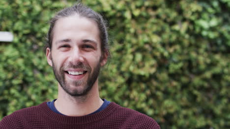 Portrait-of-happy-caucasian-man-wearing-red-jumper-in-garden,-slow-motion