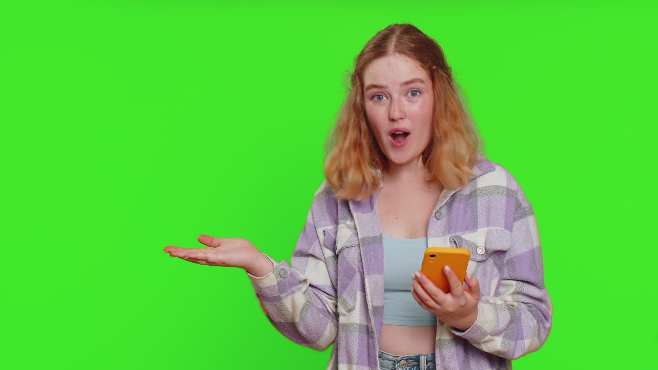 Woman using smartphone showing pointing empty place advertising application area positive feedback