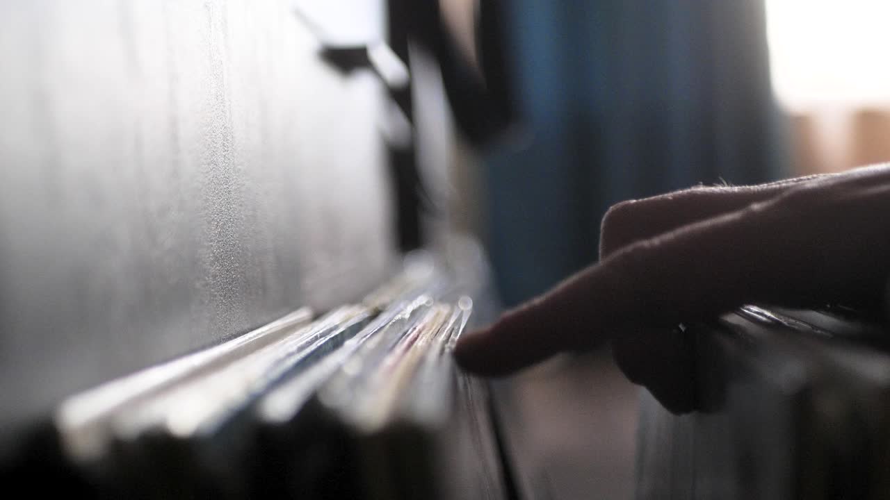 Male hands going through vinyl records, close up view