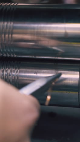 cu: craftsman processes beautiful gold chain with forge-rolling machine at workplace in light workshop closeup