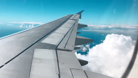 plane wing against clouds and a blue sky