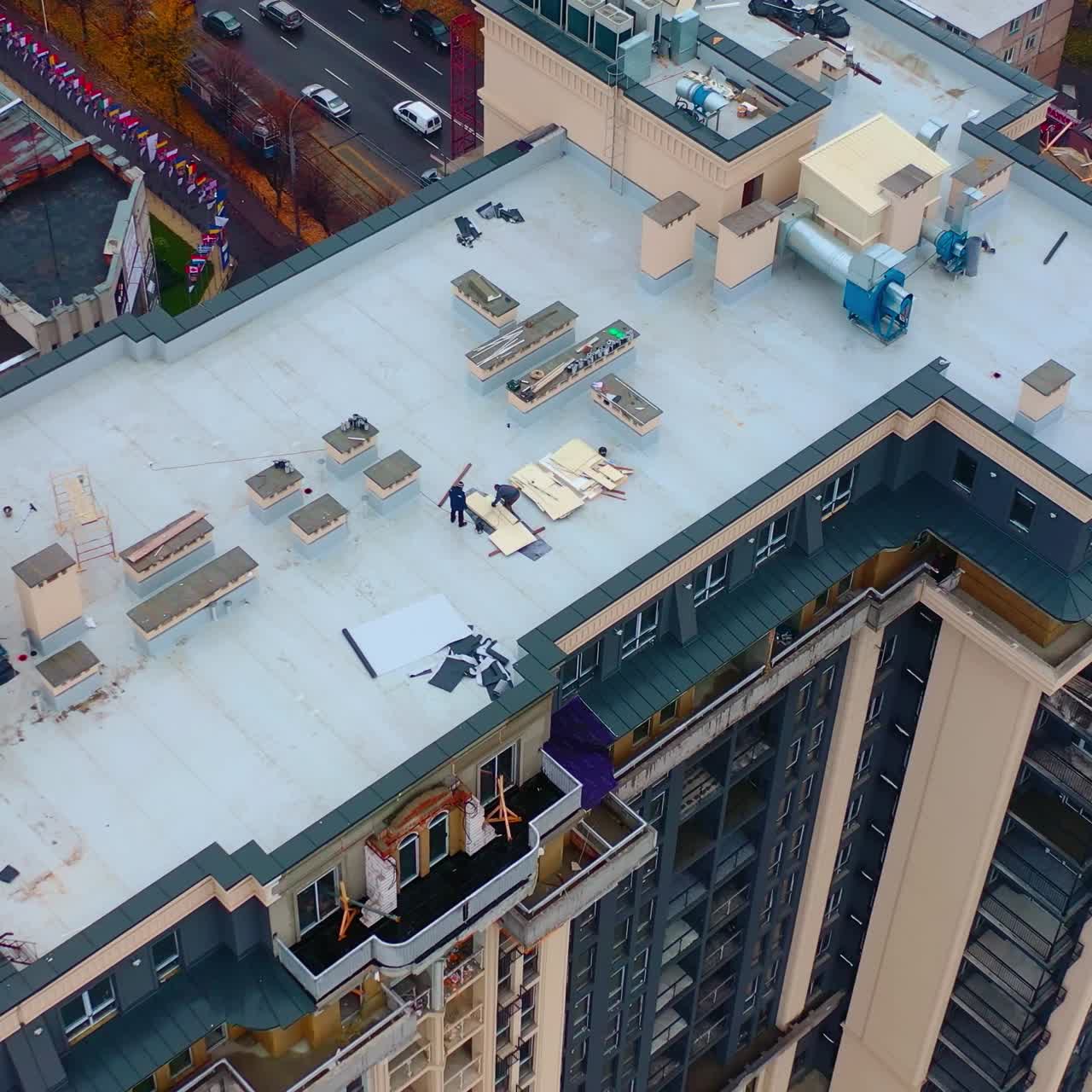 Roof of multistorey building under construction. Modern apartment house builds in the city. Workers build the tower building. Top aerial view.