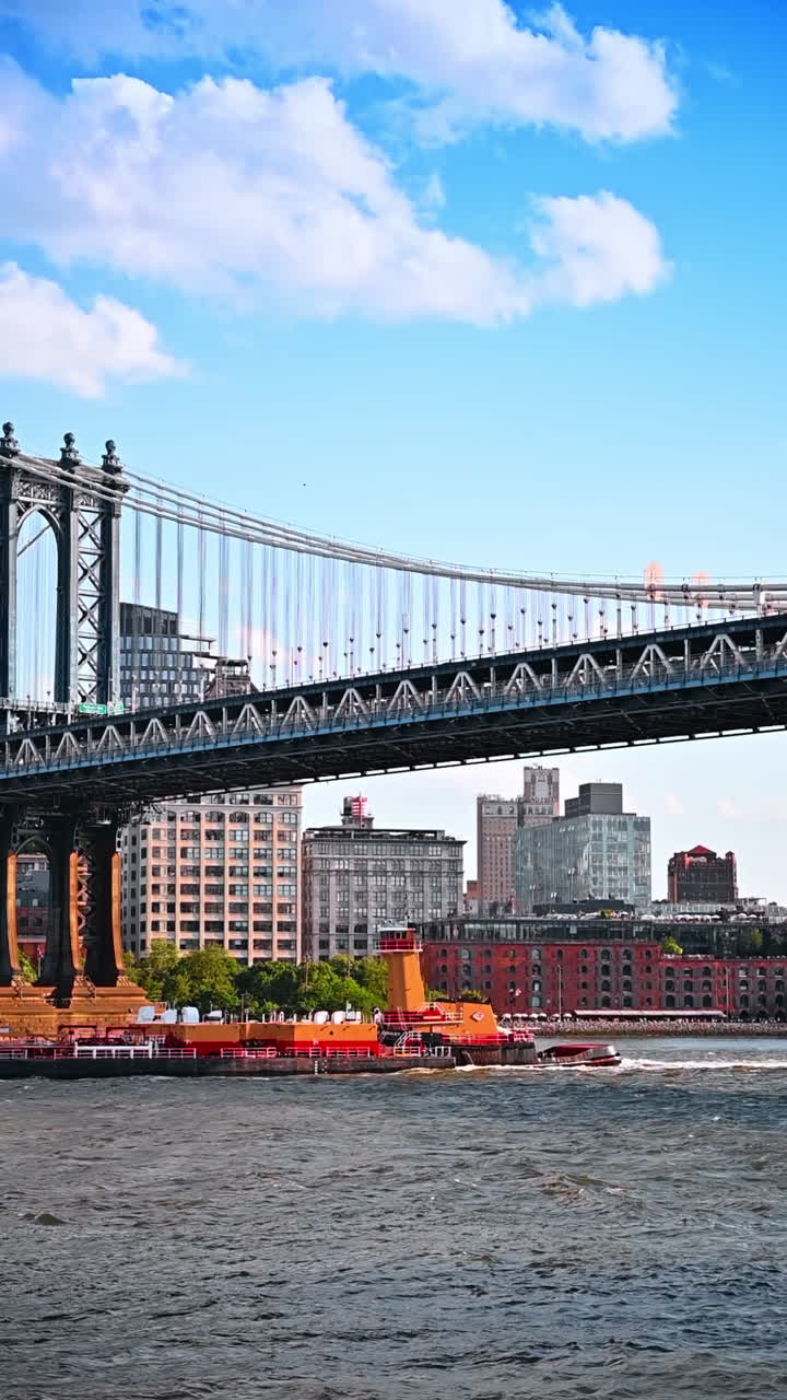 Long loaded barge moves under the Manhattan Bridge. Business logistics in New York, USA. Vertical video