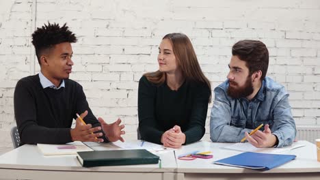 Young-african-guy-explaining-something-to-his-colleagues.-multi-ethnic-group-of-people-working-together.-Happy-diverse-group-of