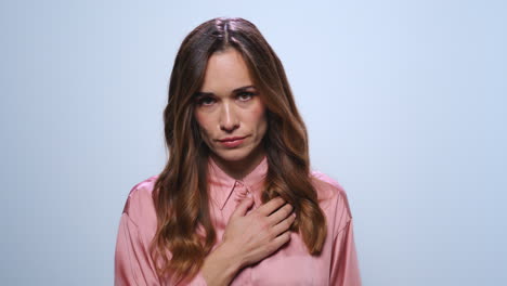 upset businesswoman looking at camera in studio. female worker looking at camera