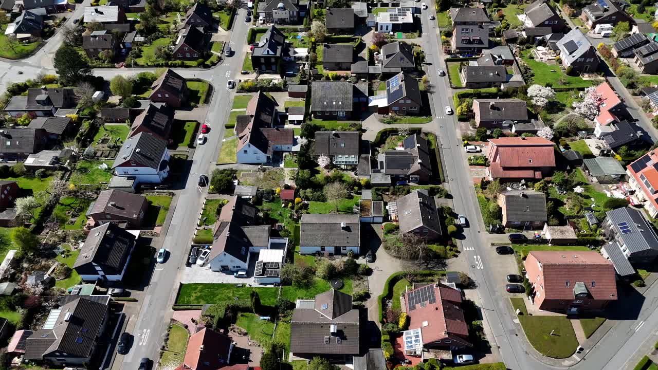 Quartiere tranquillo con case unifamiliari e villette a schiera in una giornata di sole. Bella piccola città americana con campi agricoli rurali in lontananza. Ampia ripresa aerea con movimento verso l'alto.