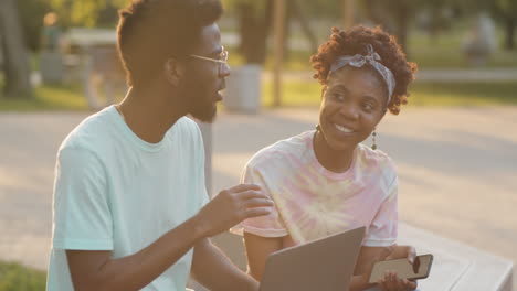 Hombre-Y-Mujer-Afroamericanos-Sentados-En-El-Parque-Y-Hablando