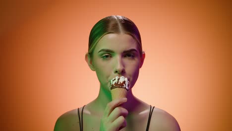 nordic blonde woman sucks an ice cream cone suggestively looking at the camera, close up portrait shot