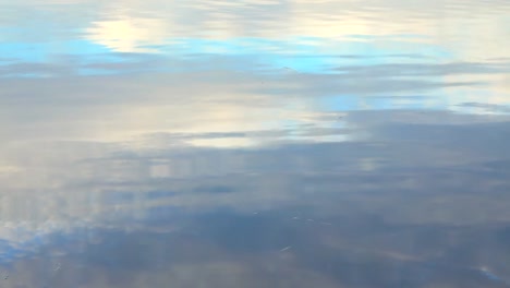 ondas de agua con reflejo del cielo de la madrugada con colores azul y naranja